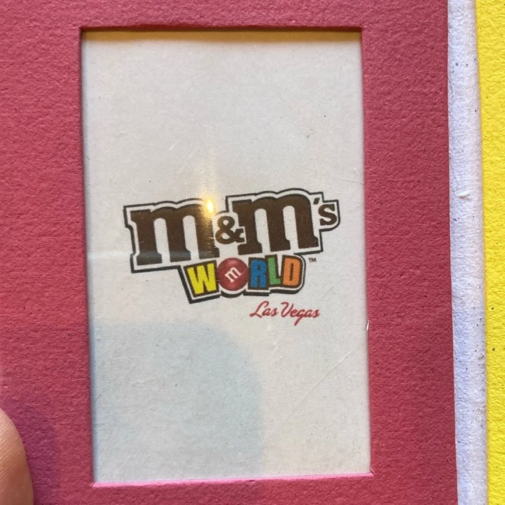 M&M'S World Logo Graphic with Red, Yellow, Blue, Green, Orange, Brown Accents